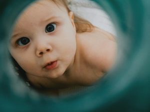 a close up of a baby curiously looking at the camera