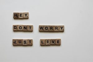 brown scrabble game tiles spelling hey don't worry just live